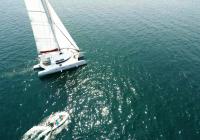multihull yacht trimaran med gummibåd jolle båd luftfoto